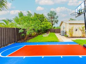 劳德代尔堡Colorful Home - Pool - Game Room - Basketball Court - BBQ & More的后院的篮球场,带围栏