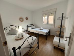 阿尔么丽亚La Pita的小房间设有两张床和窗户