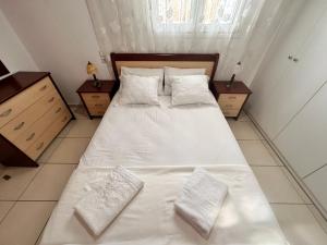 RodhodháfniCountryside Apartment Kane的一间卧室配有带白色床单和枕头的床。