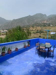 舍夫沙万house naim的一个带桌椅的蓝色山景阳台