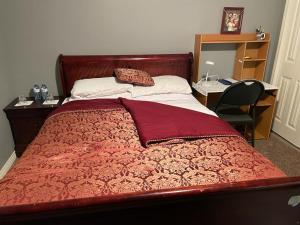 卡尔加里Steven Abode的一间卧室配有一张红色的床、一张桌子和一把椅子