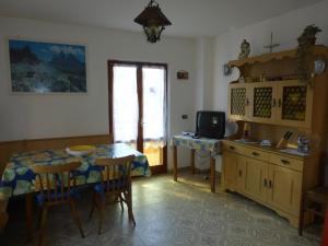 Lagolo di CalavinoCasa Pederzolli -的一间设有桌子的房间和一间带电视的厨房