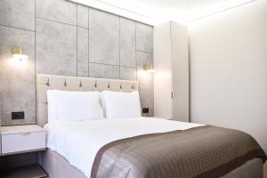 那沃达利AXO Boutique HOTEL by BUILDING STEFAN的卧室配有白色大床和白色枕头