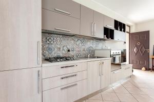 卡纳戈Apartment MisiAdele的厨房配有白色橱柜和炉灶烤箱。