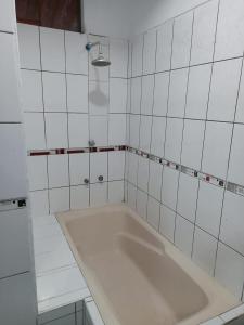 YurimaguasMajestic Mical的白色瓷砖浴室设有大浴缸