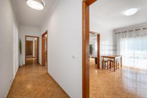 纳扎雷Porto Santo Apartment的走廊上的镜子,配有桌子和饭厅