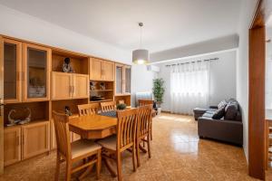 纳扎雷Porto Santo Apartment的厨房以及带木桌和椅子的用餐室。