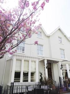 兰迪德诺Seaclyffe Hotel Ltd的前面有粉红色花的白色房子