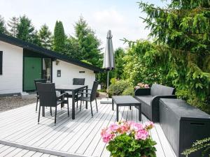 埃贝尔托夫特Holiday home Ebeltoft CLXXXI的庭院配有桌椅和遮阳伞。