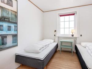 曲博伦Holiday home Thyborøn VI的配有2张床的带窗户和桌子的客房