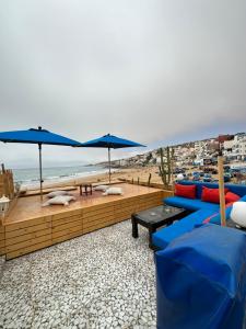 塔哈佐特Single fin beach house的海滩上带蓝色沙发和遮阳伞的庭院