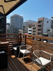 东京2023 NEW OPEN Island Japan Hotel & Cafe的阳台配有2把椅子和桌子