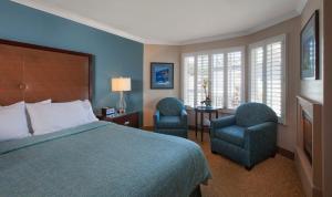 坎布里亚蓝海豚酒店 的酒店客房,配有一张床和两把椅子