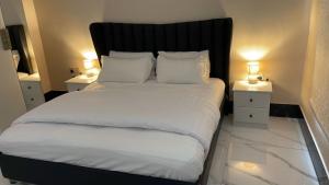 塔伊夫فلل اسوار الوسام لبيوت العطلات的一间卧室配有一张带2个床头柜的大床
