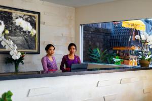 坎古Adepa Resort的两名妇女在餐厅柜台站立