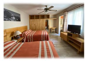 瓦哈卡市Suites Parador Santo Domingo de G.的一间卧室配有两张床和一台平面电视