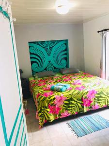 努库希瓦CHEZ ANIAKI的一间卧室配有一张带彩色床罩的床