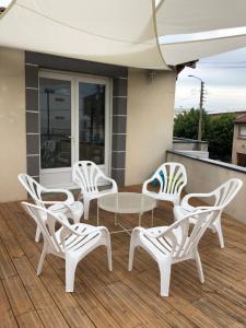 克莱蒙费朗Appartement lumineux avec grande terrasse的一组白色椅子和一张桌子