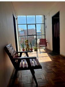 奥鲁罗Hostal Graciela的一间带长凳、桌子和窗户的房间