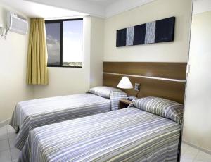 纳塔尔CJC Short Stay Natal的酒店客房设有两张床和窗户。