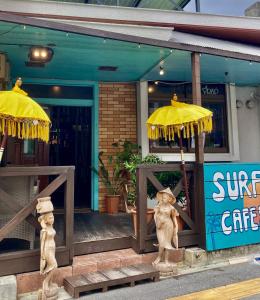 北谷町Surfer's Cafe& Hostel的前面的商店有两把伞