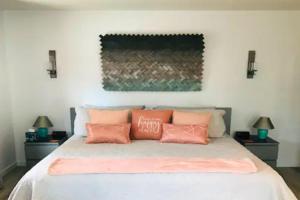 塞多纳Artsy Casita, King Bed, Walk to Trails & Food, Mountain Views, Trail Pass的一间卧室配有带粉红色枕头的床。