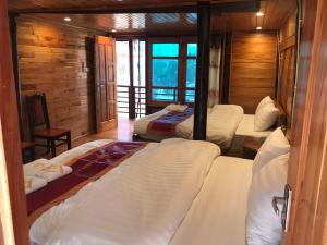 高平Tày Homestay Pác Bó - Cao Bằng的一间卧室,配有三张床