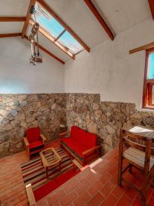 Comunidad YumaniEcolodge K'arasirca的一间设有两张红色椅子和石墙的房间
