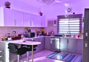 SanadLuxury Private Pool Villa for families only的厨房配有紫色橱柜和桌椅