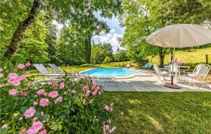 Caylus凯吕斯16号度假屋的一个带桌子和遮阳伞的游泳池以及粉红色的鲜花