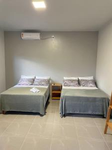 索雷Morada da Ilha Pousada的一间设有两张床的客房和墙上的加热器