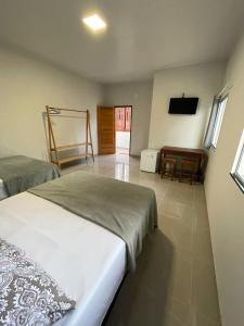 索雷Morada da Ilha Pousada的一间卧室配有两张床、一张桌子和一台电视。