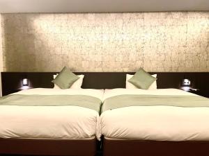 京都Homm Stay Nagi Sanjo Kyoto By Banyan Group的卧室内两张并排的床
