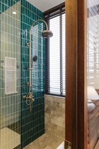 清迈Coucou Hotel的一间铺有绿色瓷砖的淋浴浴室