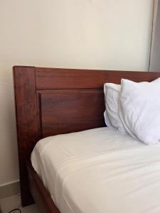 ChironguiSuite Villa au bord de la mer chez Saloua的一张带木制床头板和白色枕头的床
