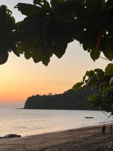 ChironguiSuite Villa au bord de la mer chez Saloua的一群人,在日落时站在海滩上