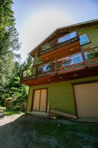 Shawnigan LakeChateau Shawnigan 2BD in West Shawn Lake的绿色房子的顶部设有阳台