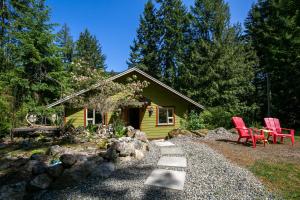 Shawnigan LakeChateau Shawnigan 2BD in West Shawn Lake的前面有两把红色椅子的黄色房子