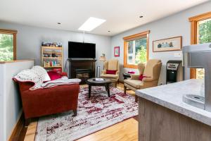 Shawnigan LakeChateau Shawnigan 2BD in West Shawn Lake的客厅配有两把椅子和壁炉