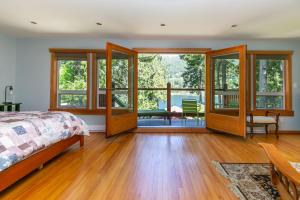 Shawnigan LakeChateau Shawnigan 2BD in West Shawn Lake的一间卧室设有床和滑动玻璃门