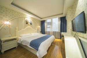 长沙莫林风尚酒店长沙涂家冲地铁站店的一间卧室配有一张大床和一台平面电视