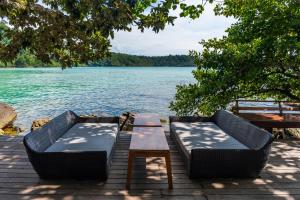 库德岛虎克船长度假村@库德岛的湖畔码头上的两把椅子和一张桌子
