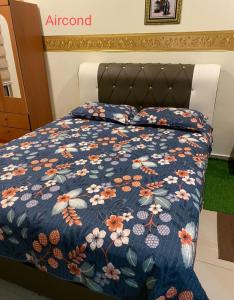 昔加末homestay sayangku islam的一张床上的蓝色被子,上面有鲜花