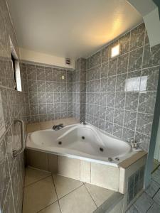 圣地亚哥Red Hotel Centric Santiago的带浴缸的浴室和瓷砖墙