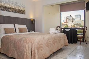 圣地亚哥Red Hotel Centric Santiago的一间设有大床和窗户的酒店客房