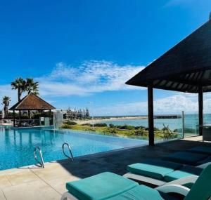 曼哲拉Villa by the Sea的毗邻大海的带躺椅的游泳池