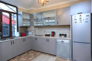 久姆里Syune Mini Hotel的厨房配有白色橱柜和冰箱。