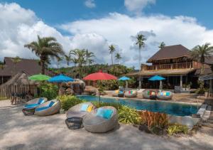 库德岛汀克贝尔@沽岛度假酒店的一个带椅子和遮阳伞的游泳池的度假酒店