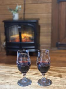 贝林真Koompartoo Retreat Bellingen的壁炉桌上的两杯红葡萄酒