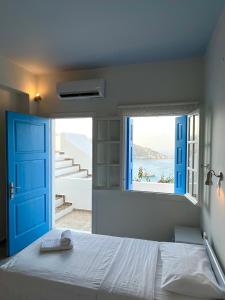 伊奥斯乔拉佩特迪酒店的一间卧室配有一张带蓝色门和窗户的床